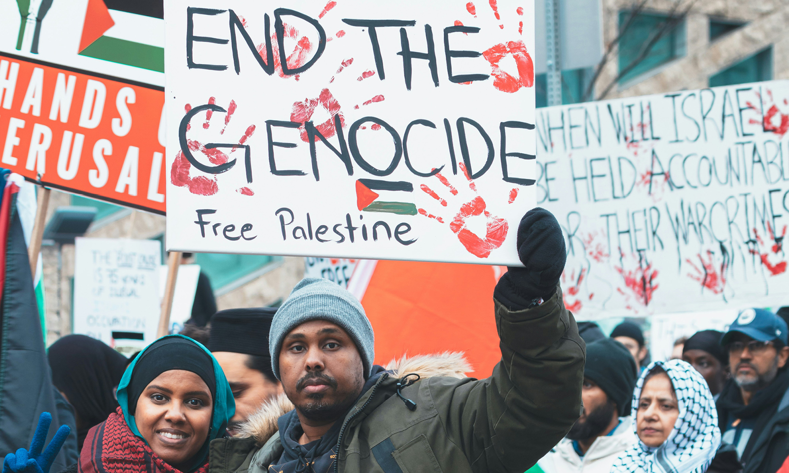 skupina ľudí držiacich transparenty: hands off Jerusalem, End the genocide, Free Palestine